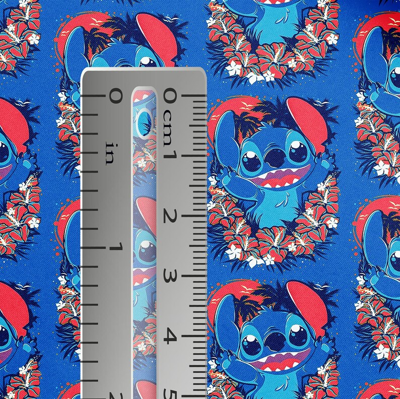 May include: Blue fabric featuring a repeating pattern of a cartoon character with large eyes, surrounded by red flowers and palm trees. A ruler shows measurements in inches. The character is blue with red ears and a red mouth.