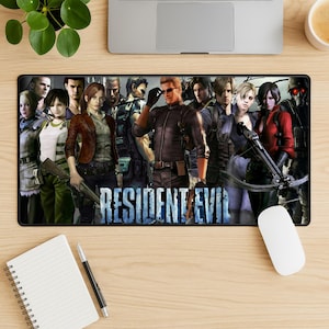 May include: A rectangular black mousepad featuring a group of characters from the video game "Resident Evil." The image includes the game's title in a blue and white font. The characters are in various action poses, with weapons.