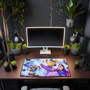 Puede incluir: Alfombrilla de rat&oacute;n rectangular para juegos con una colorida ilustraci&oacute;n de estilo anime de personajes en acci&oacute;n. La alfombrilla est&aacute; colocada sobre un escritorio de madera oscura, rodeada de plantas, l&aacute;mparas, un monitor de ordenador y altavoces.