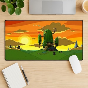 May include: A rectangular mousepad featuring a cartoon landscape with a sunset sky. The scene includes a large treehouse, green hills, and a setting sun. The color palette is dominated by orange, yellow, and green.