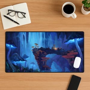 May include: A rectangular mouse mat with a fantasy scene of glowing blue mushrooms and a waterfall. The artwork shows figures around a campfire on a mushroom bridge. A white computer mouse is visible on the right side of the mat.