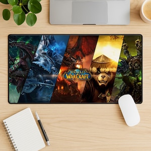 Puede incluir: Una alfombrilla de ratón rectangular con ilustraciones del videojuego World of Warcraft. El diseño está dividido en secciones diagonales, cada una mostrando diferentes personajes y escenas. La alfombrilla es negra con un ratón blanco y un bloc de notas.