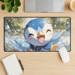 以下が含まれることがあります： 黒い長方形のマウスパッド。水しぶきの中で漫画のペンギンのキャラクターが描かれています。ペンギンは青と白で、幸せそうな表情をしています。泡と水滴がペンギンを囲み、遊び心のあるシーンを作り出しています。