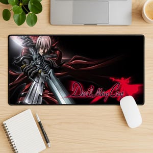 May include: Black rectangular mouse mat featuring a character from Devil May Cry, holding a large silver sword. The character has pink hair and is wearing a red coat. The words "Devil May Cry" are in red on the right side.
