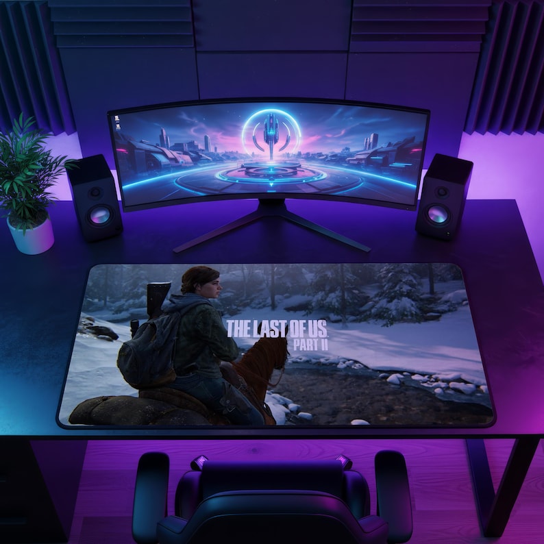May include: A gaming setup featuring a curved monitor, speakers, and a mousepad. The mousepad displays a scene from "The Last of Us Part II" with a character on horseback. The desk is black, and the background is illuminated with purple and blue lighting.