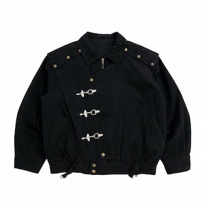 Puede incluir: Chaqueta negra con cuello, detalles en los hombros y cierre de cremallera. La chaqueta presenta tres cierres metálicos decorativos y remaches dorados. La cintura es elástica. Una prenda de vestir exterior elegante.