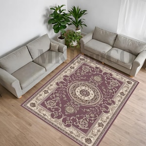 May include: An overhead view of a living room featuring two grey sofas, potted plants, and a large rectangular rug. The rug is predominantly purple with a detailed floral pattern in cream and gold.