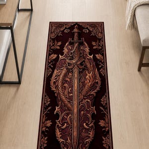 Könnte beinhalten: Ein rechteckiger Teppich mit tiefburgunderrotem Hintergrund und einem zentralen Motiv eines metallisch bronzefarbenen Schwertes, das von einer Schlange umschlungen ist. Das komplexe Design zeigt kunstvolle Schnörkel und Blattmotive.