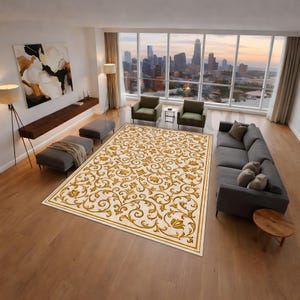 May include: A large rectangular rug featuring an ornate gold floral pattern on a cream background. The rug has a gold border. It is placed in a modern living room with a city skyline visible through a large window.
