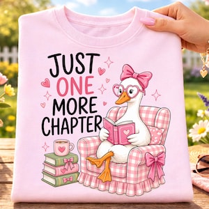 May include: Pink sweatshirt with the text "JUST ONE MORE CHAPTER" and a cartoon goose wearing heart-shaped glasses and a bow, reading a book. The goose is seated in a pink gingham armchair. A stack of books and a coffee cup are also shown.