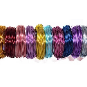 May include: A collection of 10 spools of colorful metallic wire. The wire is wound tightly around each spool, creating a rainbow effect. The colors include gold, purple, pink, blue, teal, silver, and red.