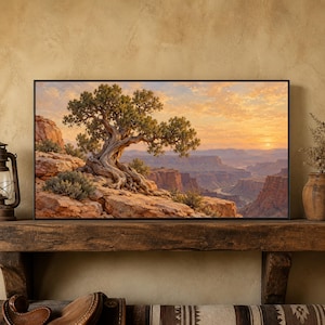 May include: A rectangular framed landscape print featuring a gnarled juniper tree perched on a rocky canyon edge at sunset. The sky is filled with soft orange and yellow clouds, while the deep canyon below is bathed in warm, golden light.
