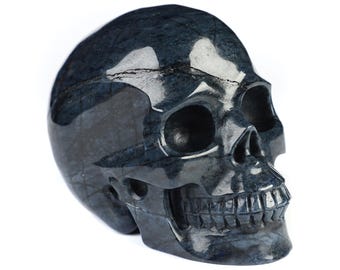 May include: A black and blue gemstone skull sculpture. The skull is carved in detail, with visible teeth and eye sockets.