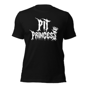 May include: Black t-shirt with the white text "Pit Princess" in a gothic font, and a small crown graphic. The shirt is a short-sleeved crew neck.