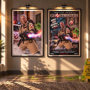 May include: Two framed movie posters featuring a person in a tan jumpsuit holding a proton pack with a glowing energy beam. The posters display the text Brian Steel Ghostbusters Who You Gonna Call and show a green ghost and a white vehicle.