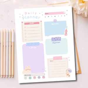 May include: A pastel-colored daily planner with the words "Daily Planner" at the top. The planner includes sections for goals, reminders, to-do lists, and notes. Decorative elements include a bunny illustration and various pastel-colored accents.
