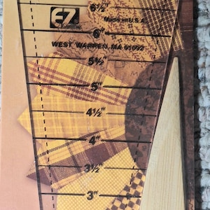 May include: A clear plastic EZ Quilting Easy Dresden ruler by Darlene Zimmerman with markings from 2.5 to 8 inches, packaged with a light wood creaser tool and three small embroidered insect patches: a butterfly, a ladybug, and a dragonfly.