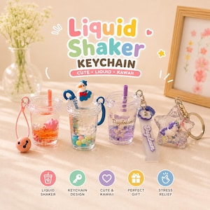 May include: A selection of liquid shaker keychains in the shape of drinks cups. The keychains contain decorative elements and come in various designs, including a duck, stars, and the word "Daydream". The text "Liquid Shaker Keychain" is visible.
