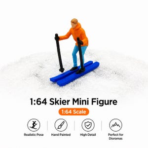 May include: A miniature skier figure in an orange jacket and blue pants, poised on blue skis with black poles. The figure is set against a white, snowy backdrop. Text reads "1:64 Skier Mini Figure" and "1:64 Scale".