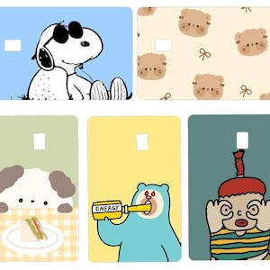 K&ouml;nnte beinhalten: Eine Sammlung farbenfroher Kartendesigns mit Cartoon-Charakteren und Illustrationen. Designs umfassen Snoopy mit Sonnenbrille, niedliche B&auml;rengesichter, einen Hund mit einem Sandwich, einen blauen B&auml;ren, der "ENERGY" trinkt, und eine Figur mit rotem Hut.