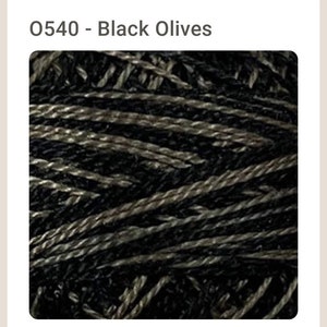 May include: Close-up of a skein of black and gray yarn. The yarn is twisted and has a textured look.