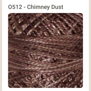 May include: Close-up of a spool of brown embroidery floss. The floss is a dark brown color with a slight sheen. The floss is tightly wound on the spool.