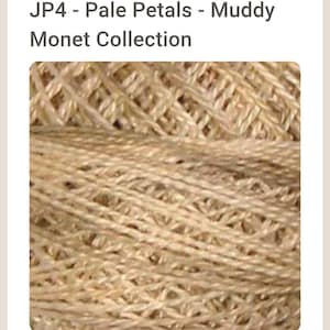 May include: Close-up of a ball of beige yarn with a woven texture. The yarn is part of the "Pale Petals - Muddy Monet Collection". The yarn appears to be made of natural fibers, with a slightly rough and textured appearance.
