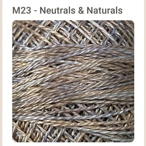 May include: A close-up of a skein of yarn in a neutral color palette. The yarn is a blend of brown and silver threads, creating a subtle, textured look.