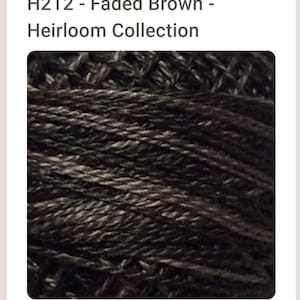 May include: Close-up of a spool of dark brown embroidery floss. The floss is tightly wound and has a slightly textured surface.