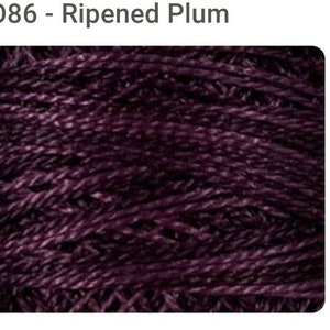 May include: Close-up of a deep purple yarn skein. The yarn is textured and has a subtle sheen.