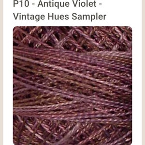May include: Close-up of a skein of purple yarn with a subtle sheen. The yarn is tightly wound and has a textured appearance. P10 - Antique Violet - Vintage Hues Sampler.