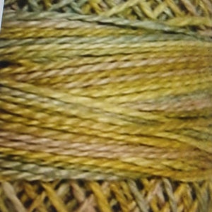 May include: Close-up of a skein of yarn in shades of green, brown, and beige. The yarn is twisted and textured, creating a rustic and natural look.