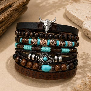 May include: A multi-layered bracelet featuring a silver-tone bull skull charm, dark brown leather straps, and various beads. The design includes turquoise-colored accents, wooden beads, and a central silver-tone oval charm with a turquoise inlay.