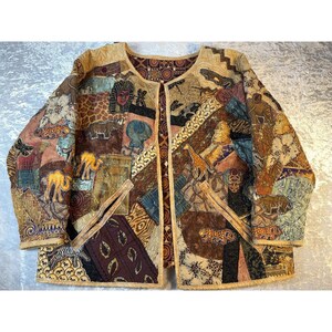 May include: A long-sleeve jacket featuring a patchwork design with various printed motifs including Egyptian pharaohs, camels, giraffes, leopards, and rhinoceroses. The garment has a round neckline, an open front, and two front pockets.