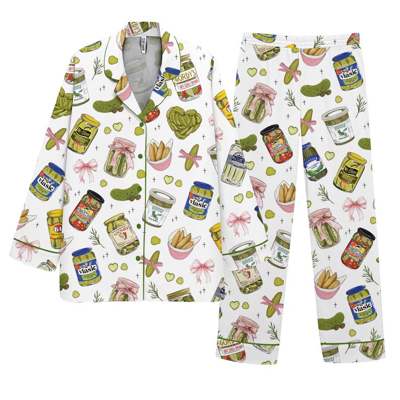 May include: White pajama set with a repeating pattern of pickles, jars, and pink bows. The long-sleeved top has green trim and buttons. The pants have an elastic waistband. The pajama set is made of a soft, comfortable material.