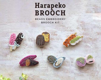 Puede incluir: Colección de kits de broches bordados con diseños de comida. Los broches incluyen un helado, pan y otros alimentos. El texto "Harapeko BROOCH" se muestra encima de los broches.