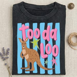Może przedstawiać: Czarny t-shirt z kresk&oacute;wkowym kangurem i napisem "Tooda Loo" w kolorze r&oacute;żowym. Projekt zawiera niebieskie pionowe paski i gwiazdki w kolorze zielonym i r&oacute;żowym.