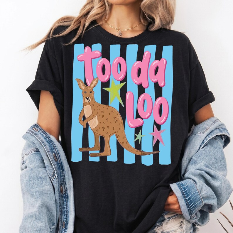 Może przedstawiać: Czarny t-shirt z kresk&oacute;wkowym kangurem i napisem "Tooda Loo" w r&oacute;żowych literach bąbelkowych. Kangur jest brązowy, na tle niebieskich pionowych pask&oacute;w i kolorowych gwiazd.