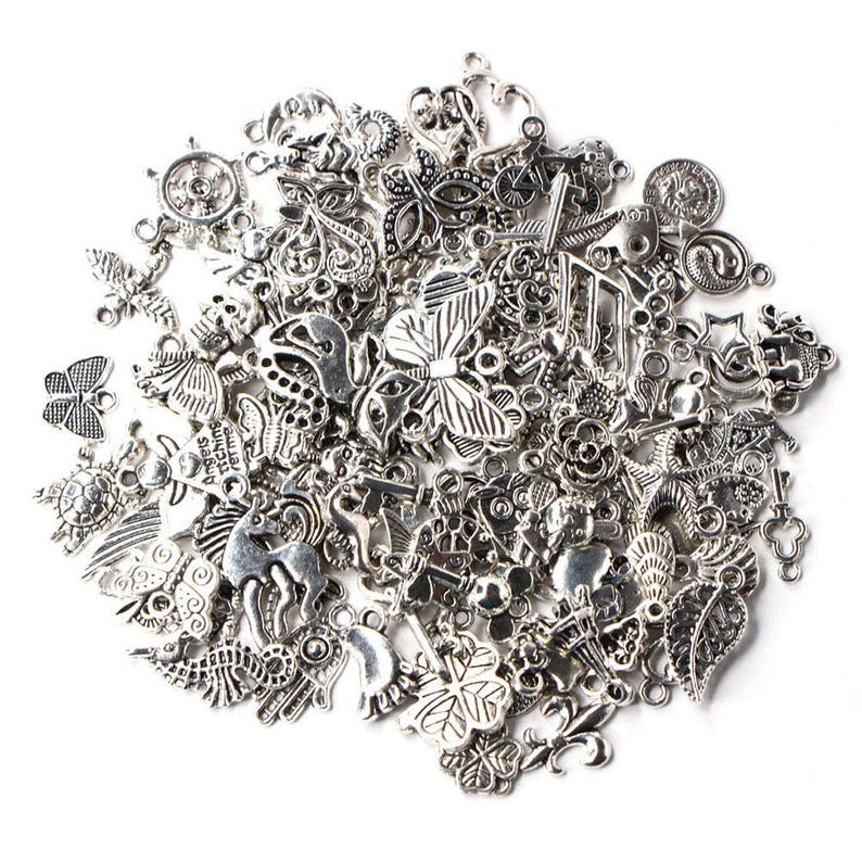 Puede incluir: Un gran surtido de abalorios de metal plateado, incluyendo mariposas, corazones, estrellas y otros dise&ntilde;os decorativos. Los abalorios son perfectos para la elaboraci&oacute;n de joyas, el scrapbooking y otros proyectos de manualidades.