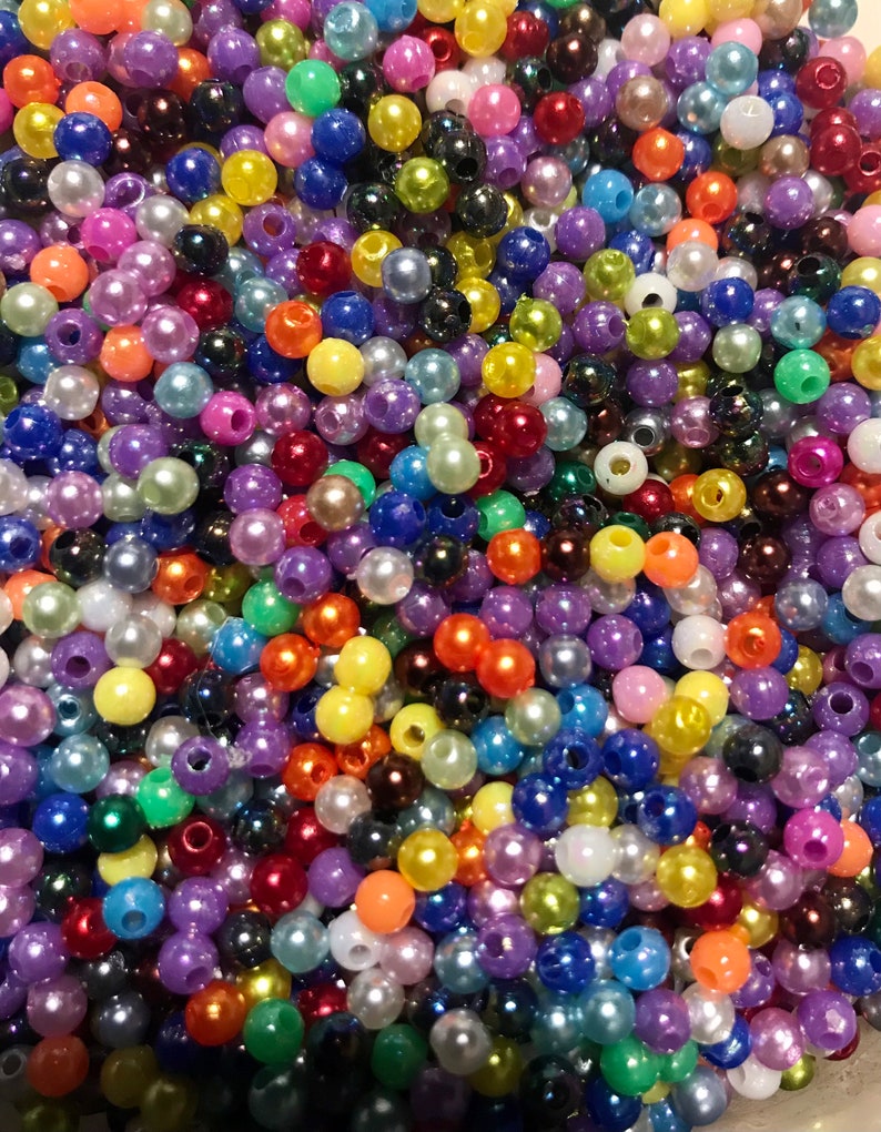 May include: A large assortment of colorful plastic beads. The beads are round and have a pearlescent finish. They are perfect for crafting projects.