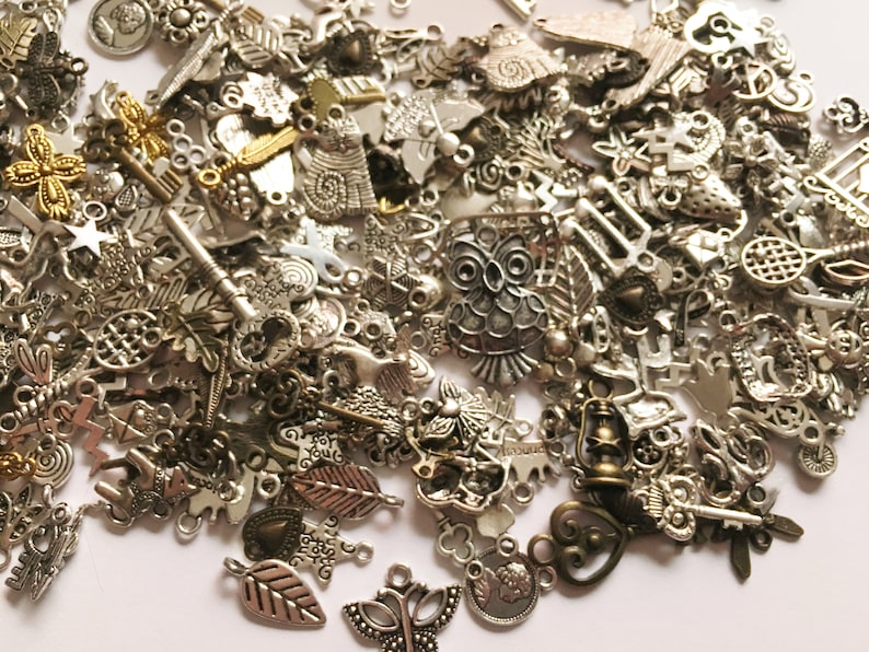 Puede incluir: Un gran surtido de abalorios de metal plateado y dorado, incluyendo b&uacute;hos, llaves, hojas, corazones y estrellas. Los abalorios son perfectos para la elaboraci&oacute;n de joyas, el scrapbooking y otros proyectos de manualidades.