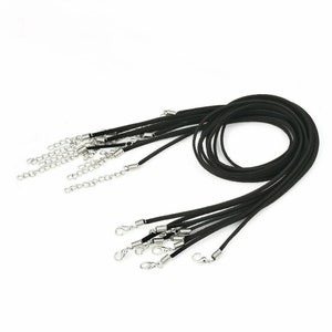 May include: A set of 10 black suede cord necklaces with silver spring ring clasps. Each necklace is approximately 18 inches long.