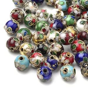 May include: A collection of colourful, round, enamel beads with gold accents. The beads are decorated with floral patterns and come in a variety of colours, including red, blue, green, white, and black.