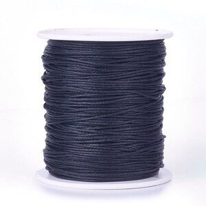 May include: A spool of black waxed cotton cord, ideal for jewellery making, crafts, and macrame projects.