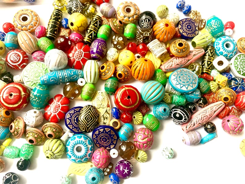 May include: A large assortment of colorful, patterned, and textured beads. The beads are made of various materials, including wood, glass, and plastic. They are perfect for jewelry making, crafting, and home decor.