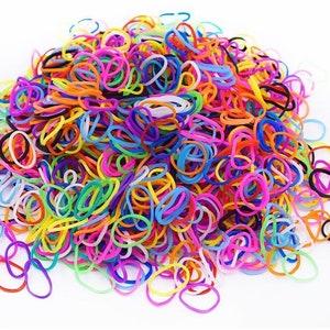 May include: A large pile of colorful rubber bands in various shades of pink, purple, blue, green, yellow, orange, and black. The bands are scattered and intertwined, creating a vibrant and playful display. Ideal for crafts and accessories.