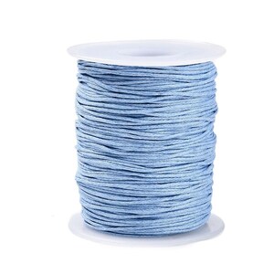 May include: A spool of light blue waxed cotton cord, perfect for jewelry making, macrame, and other crafts.