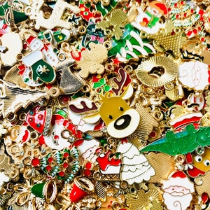 May include: A large assortment of gold-tone metal Christmas charms featuring various holiday themes. The charms include reindeer, Santa Claus, Christmas trees, bells, snowflakes, and other festive designs.