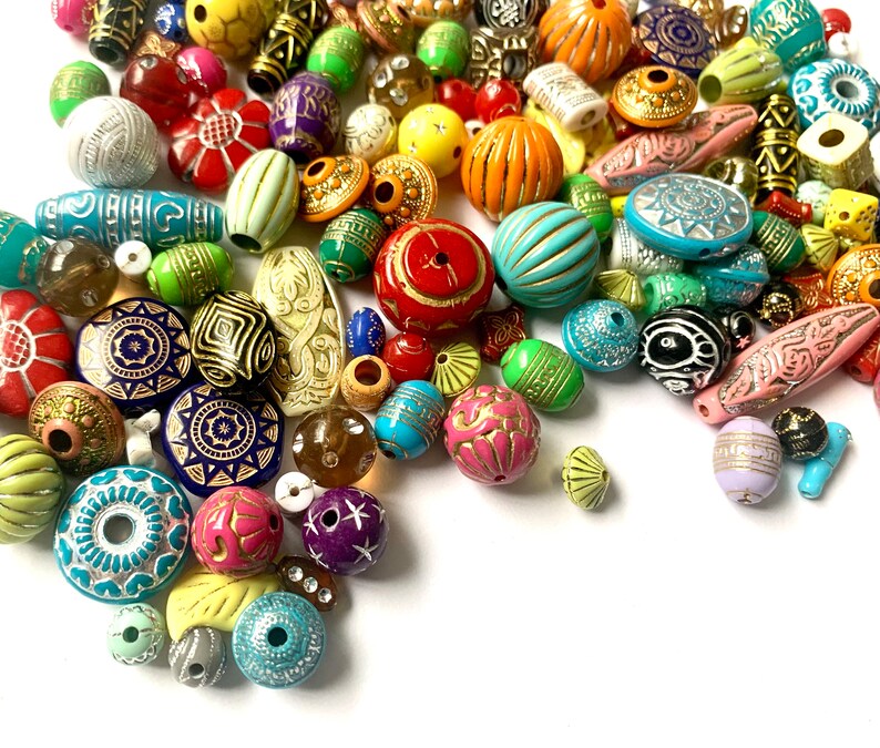 May include: A large assortment of colorful, patterned, and textured beads. The beads are made of various materials, including plastic, glass, and wood. They are perfect for jewelry making, crafting, and home decor.
