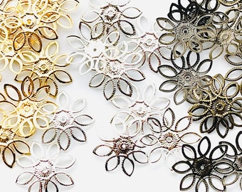 May include: An assortment of filigree flower-shaped metal components in various finishes, including gold, silver, bronze, and black. These decorative pieces feature a central floral design with delicate petal details, ideal for jewelry making or craft projects.